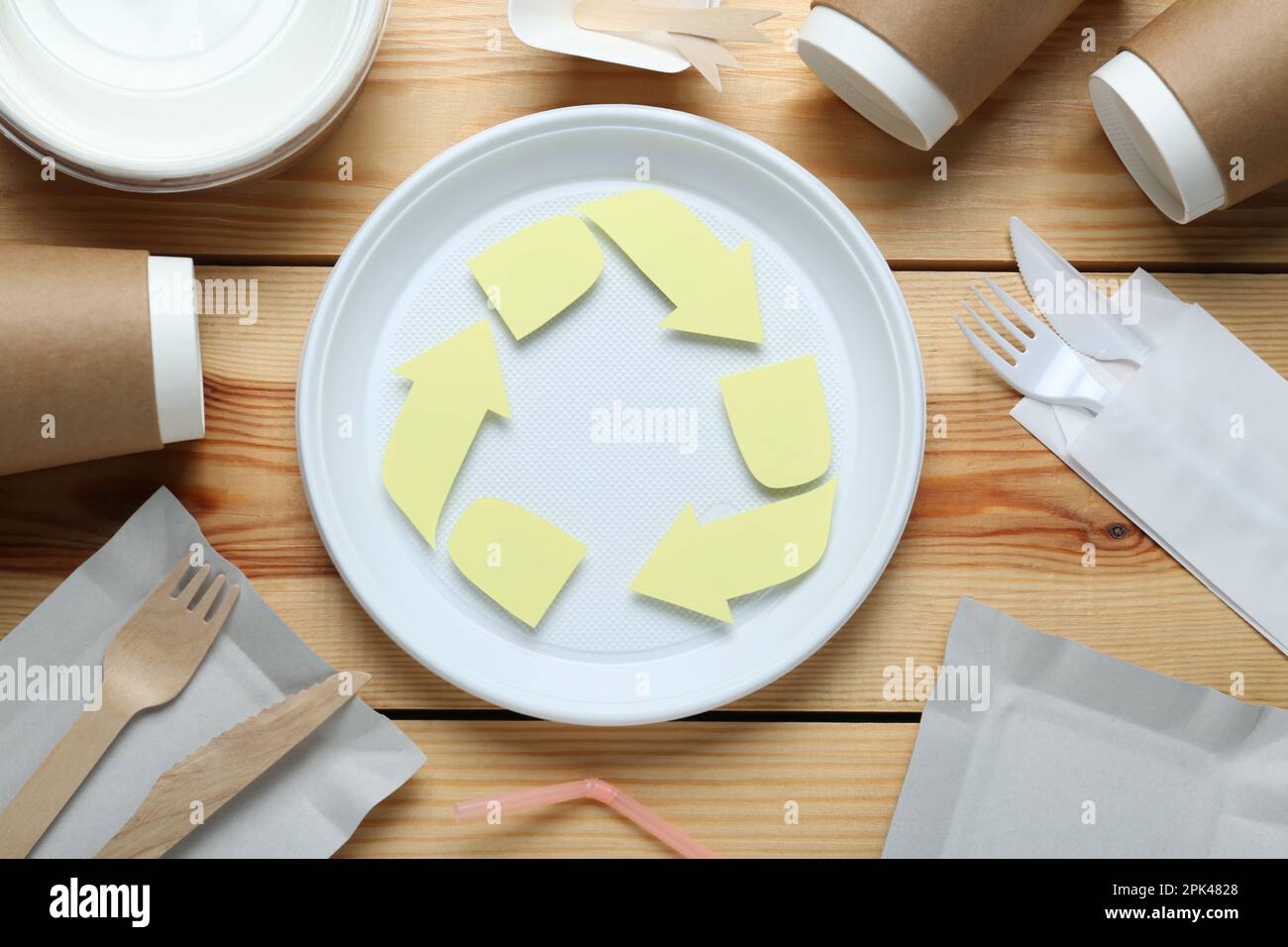 Flat lay composition with disposable dishware and recycling symbol on ...