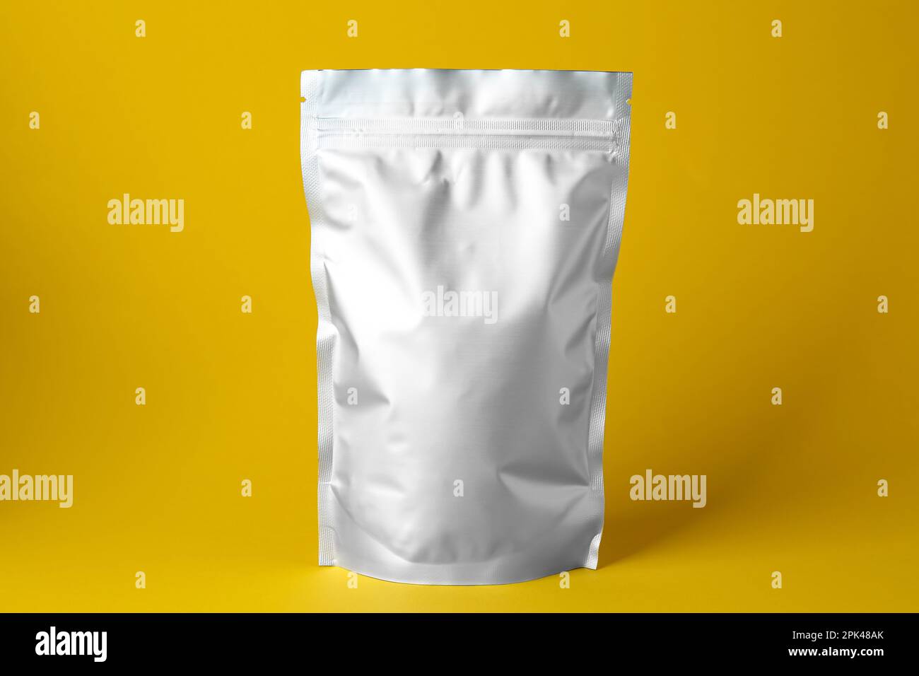 One blank foil package on yellow background Stock Photo
