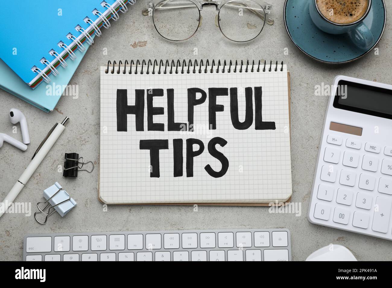 Flat lay composition with text Helpful Tips in notebook on grey table Stock Photo