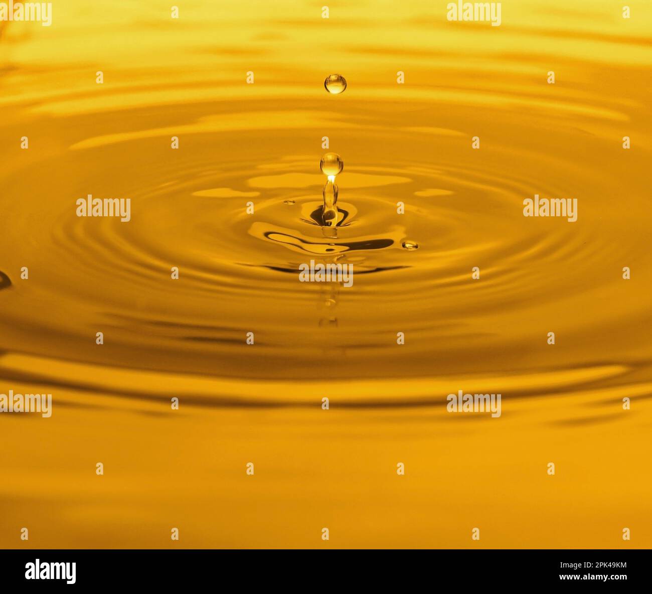 Splash of golden oily liquid with drops as background, closeup Stock ...