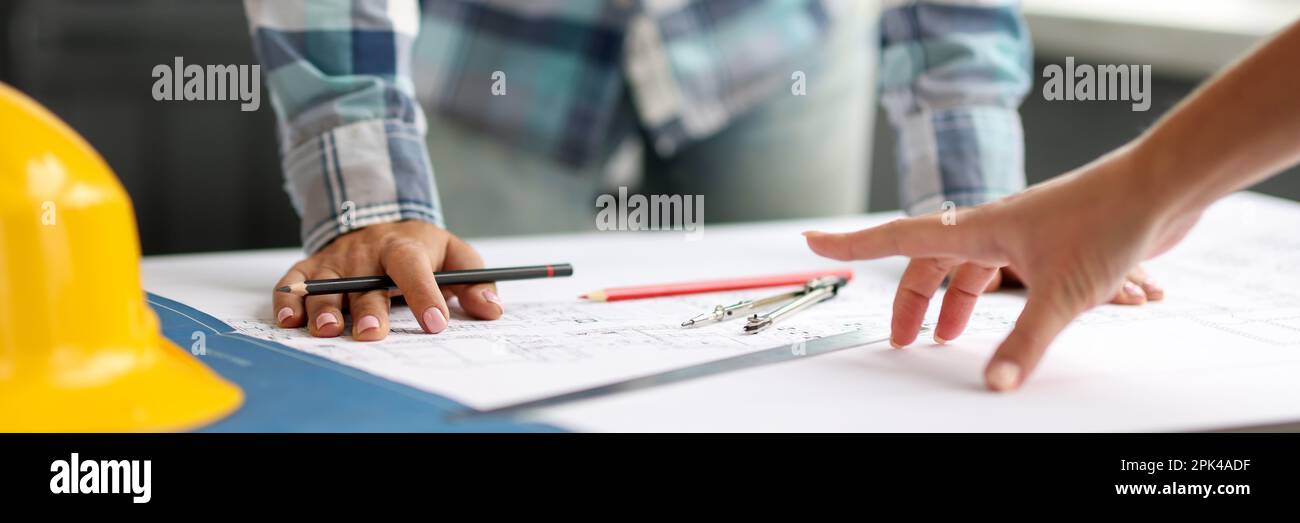 Architect discussing project with colleague using blueprints Stock Photo