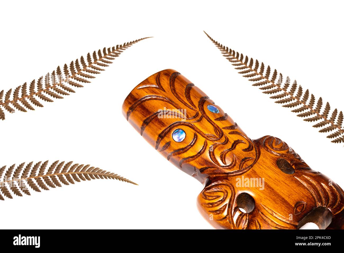 New zealand symbol, traditional maori carving and silver fern leaves, white background, close up Stock Photo