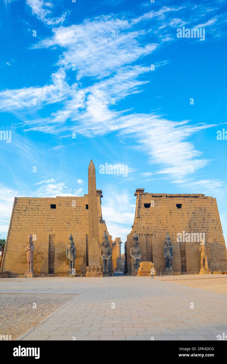 The Pylon of Ramesses ll with the Eastern Obelisk and the Two Colossi of the King seated on his Throne, Luxor Temple, Luxor, Egypt, North East Africa Stock Photo