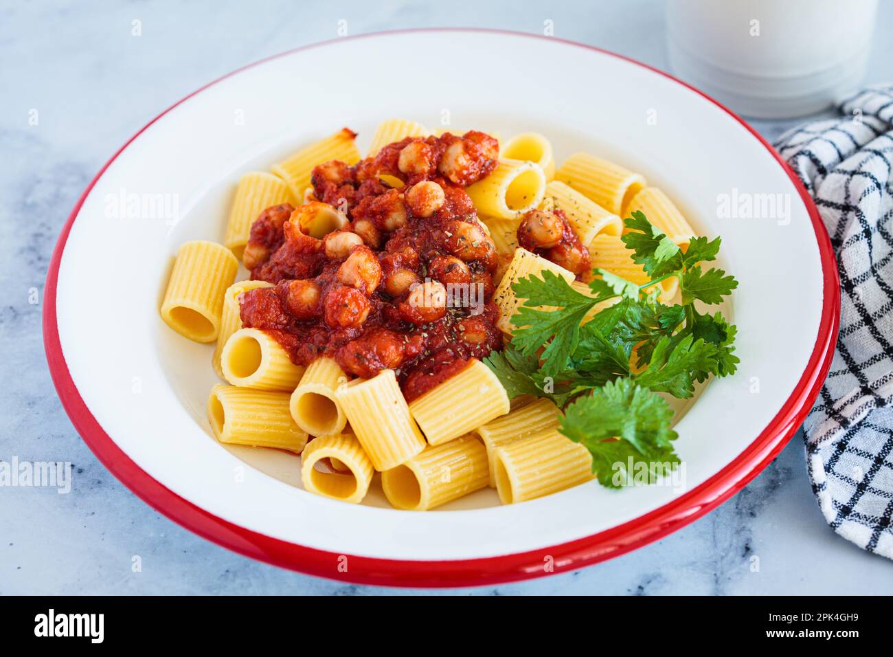 Vegan rigatoni pasta with chickpeas and tomato sauce in white plate