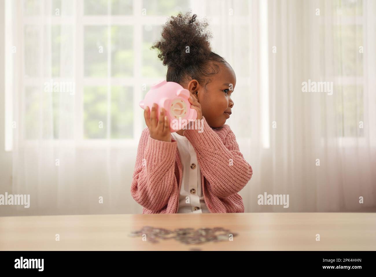 Little girl putting coin of cash into ceramic piggy bank Stock Photo ...