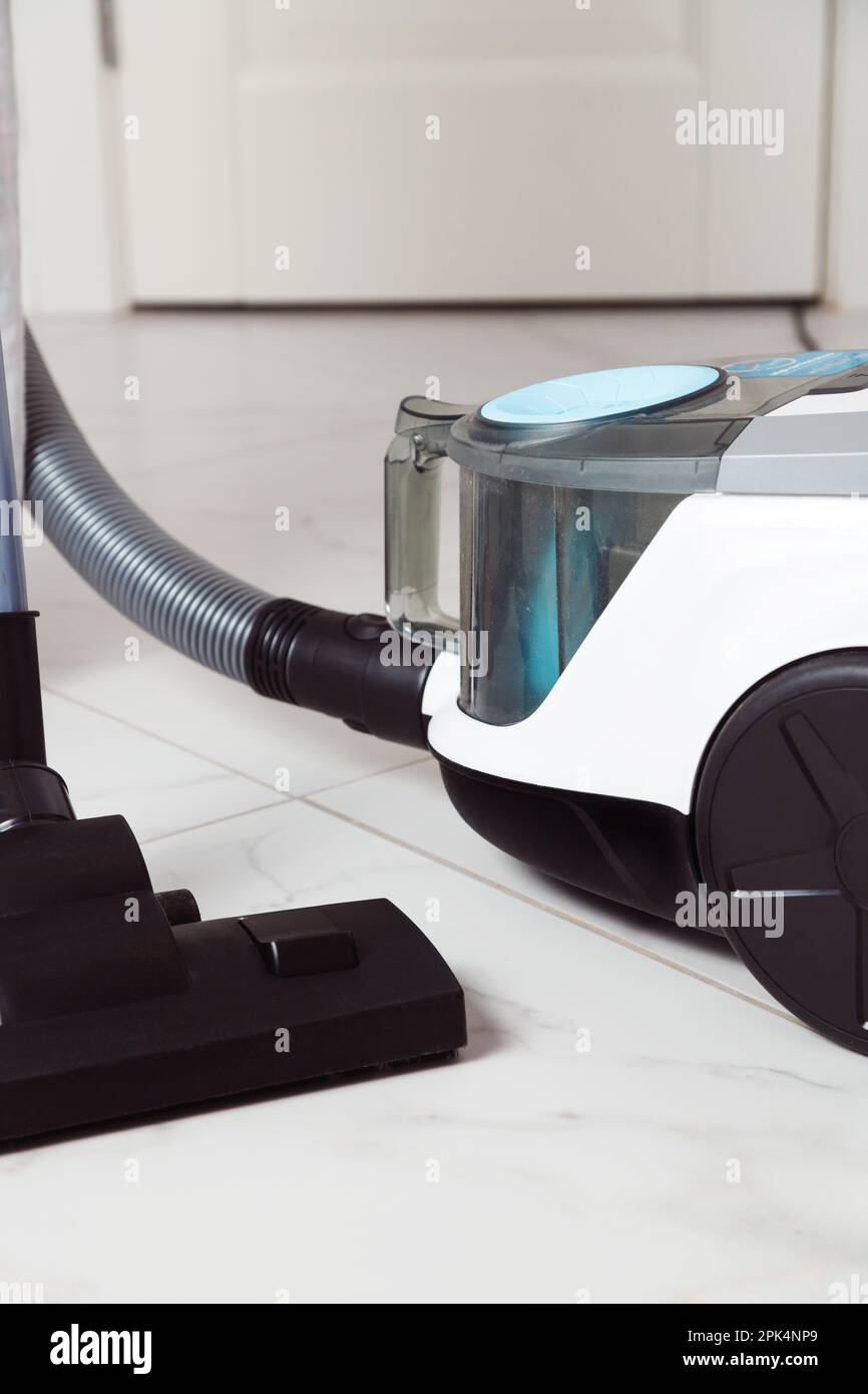 Vacuum cleaner with plastic dust container, hose and brush on flat