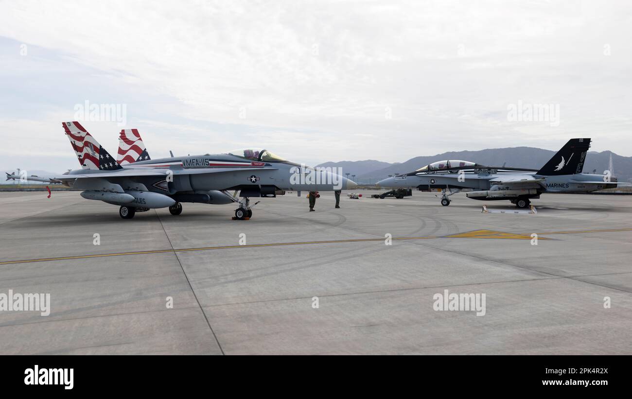 U.S. Marine Corps F/A-18s with Marine Fighter Attack Squadron (VMFA) 115 link an ATM-84K SLAM-ER missile to an AN/AWW-13 Advanced Datalink pod during a hot loading exercise during a hot loading validation event at Marine Corps Air Station Iwakuni, Japan, March 24, 2023. Marines with VMFA-115 conducted the first ever hot load of an AGM-84D Harpoon missile during a validation event. The validation further enables loading of different types of ordnance while the aircraft is running, giving greater capability and increased sortie generation of tactical aircraft in the Indo-Pacific. (U.S. Marine Co Stock Photo