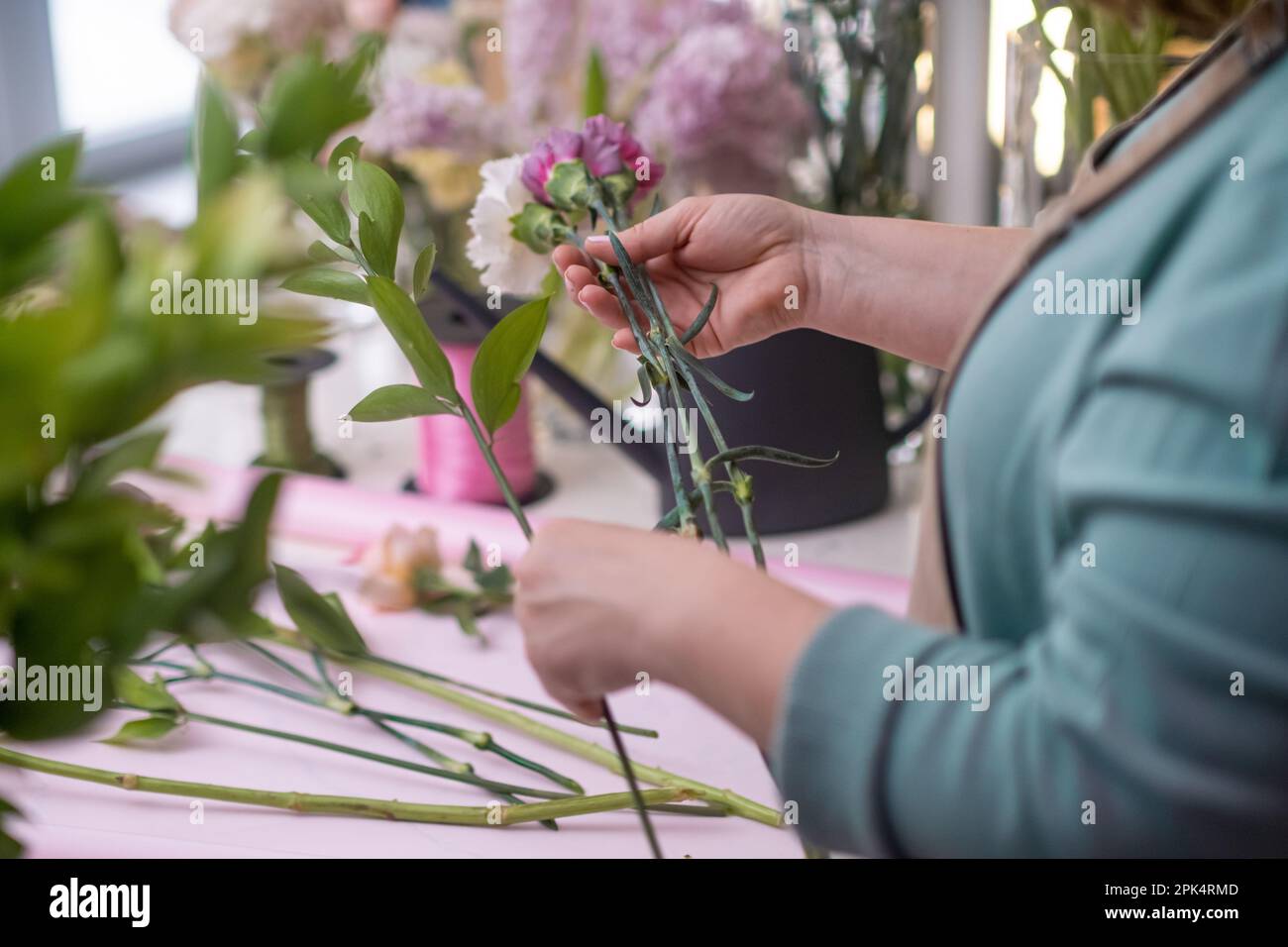 close up flower shop owner crafts a breathtaking arrangement of pink