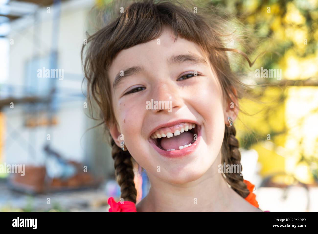 Toothless happy smile of a girl with a fallen lower milk tooth closeup