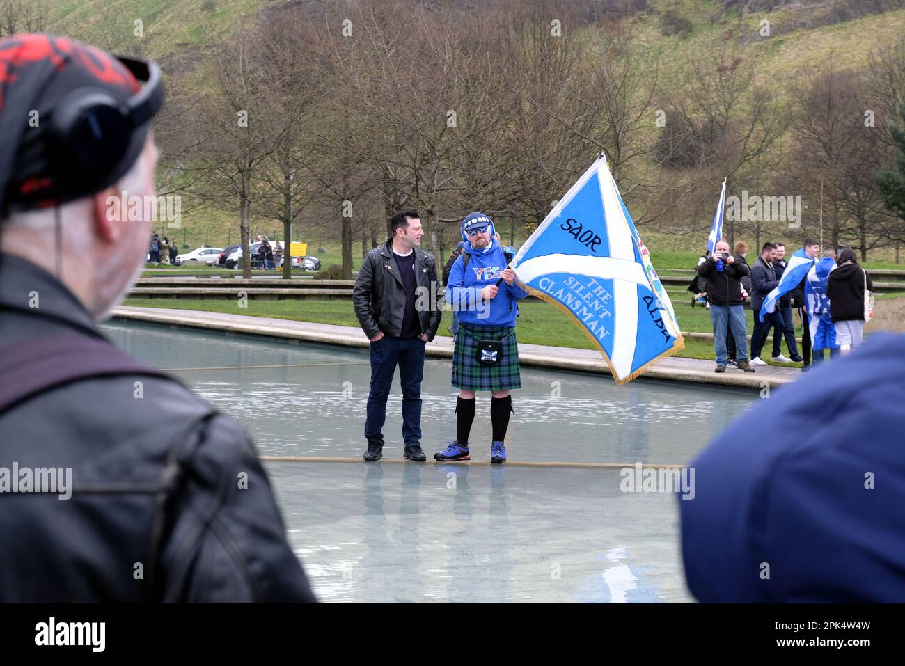 Edinburgh, Scotland, UK. 1st April 2023. A March for Scottish independence organised by Yes2Independence, commencing at Johnston Terrace in view of Edinburgh castle then marching down the Royal Mile and finishing at the Scottish parliament at Holyrood.  Standing in the ornamental pond outside the Scottish parliament at Holyrood. Credit: Craig Brown/Alamy Live News Stock Photo