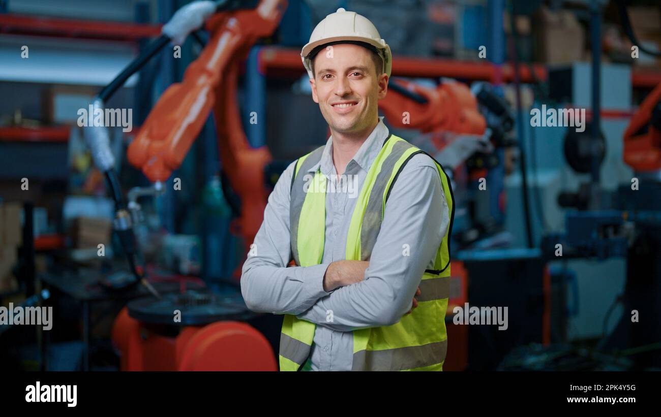 Portrait of male engineer working with robotic arms in factory Stock ...