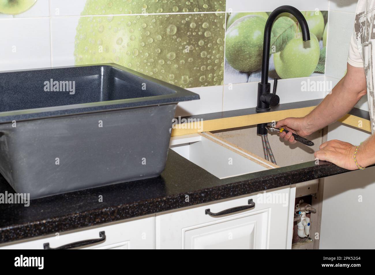 Installation of plumbing fixtures and sinks in the kitchen. The man is