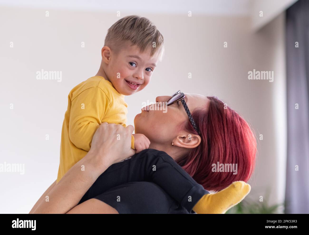 mother and child with Down syndrome exploring creativity with toy blocks, enjoying relaxing activity Stock Photo