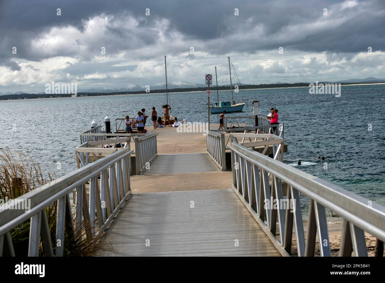 People enjoying at Shoal Bay beach Jetty, Port Stephens, Mid North Coast, New South Wales, Australia. Shoal Bay is the most eastern suburb of the Port Stock Photo