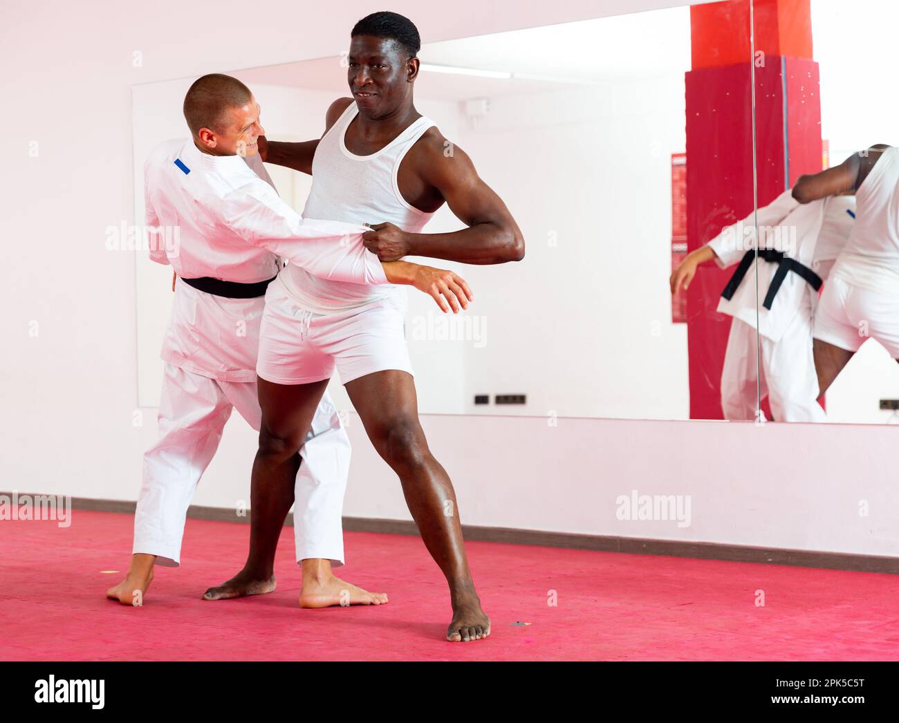 Man training throws on trainer during judo training Stock Photo