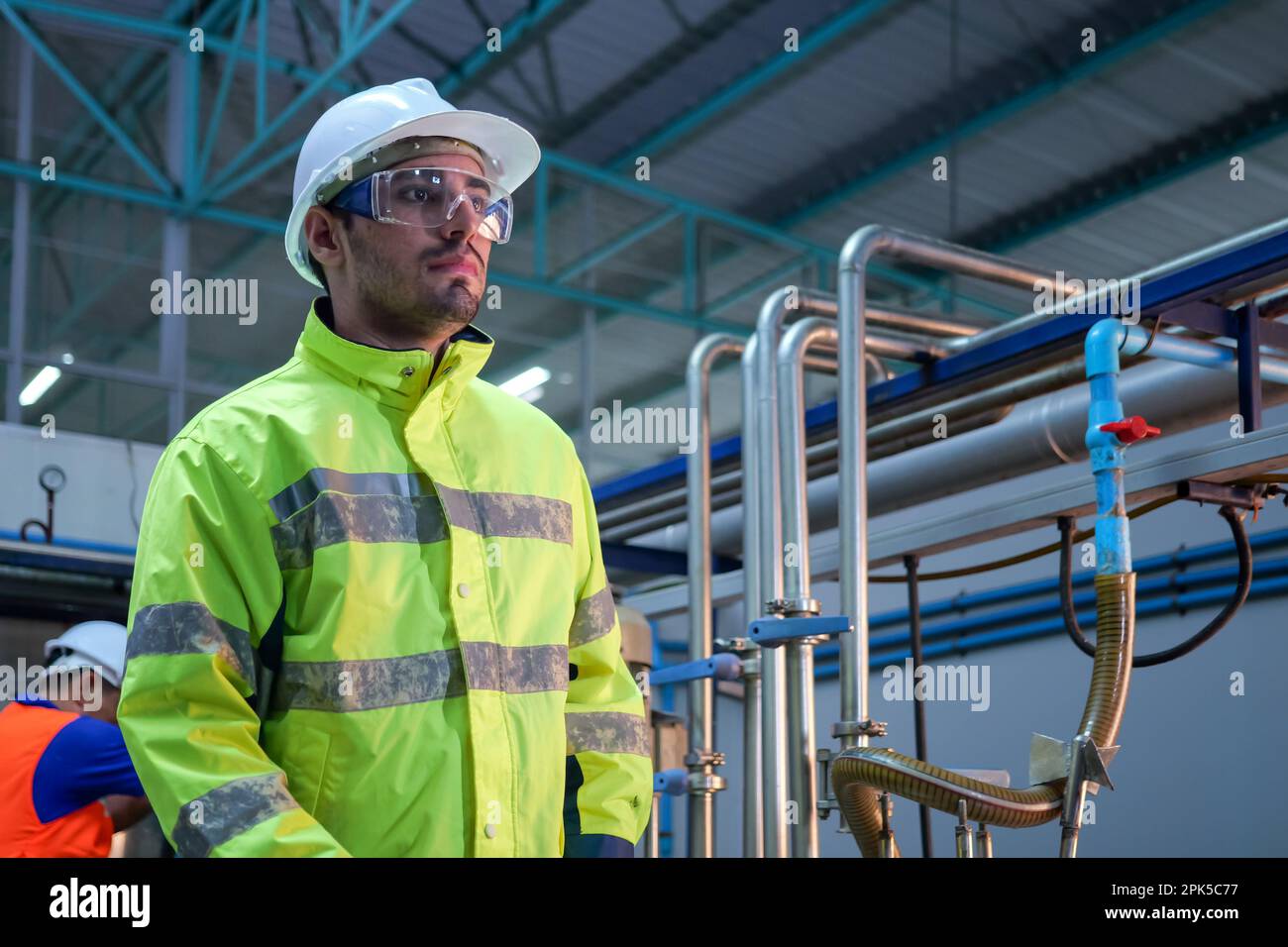 Engineer specialist using laptop checking and maintaining machine in factory Stock Photo