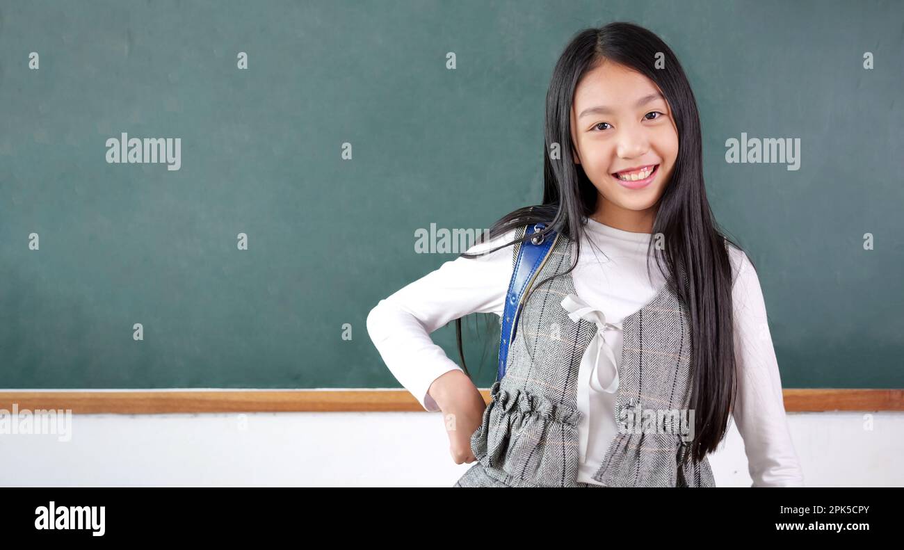 Happy schoolgirl with schoolbag portrait in the classroom Stock Photo ...