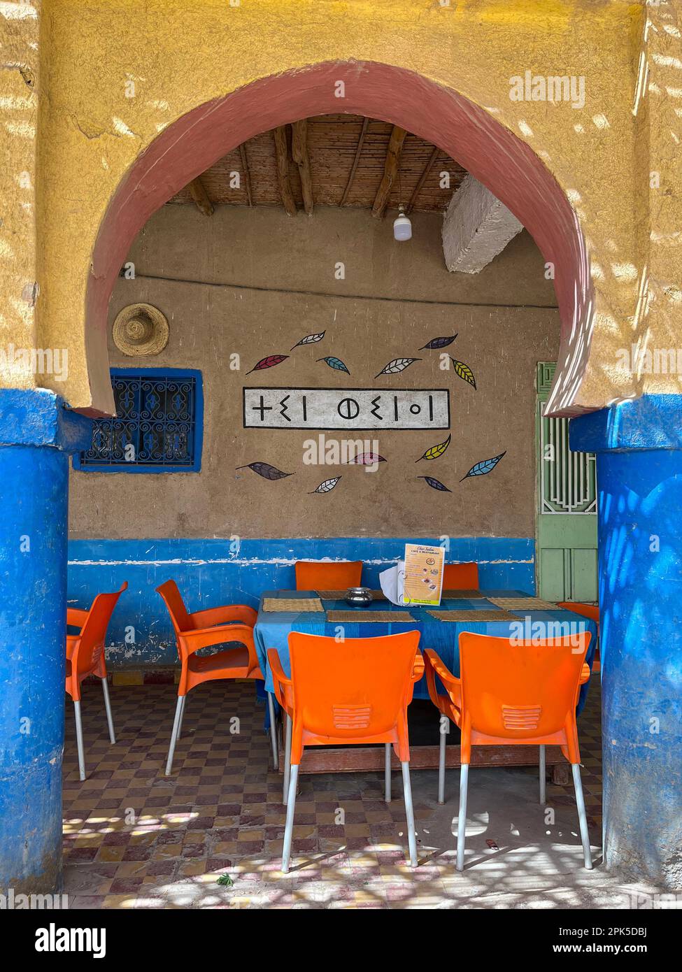 Sahara Desert, Morocco, Africa:  outdoor tables in a restaurant with a Berber sign in Merzouga, departure city for tourists visiting Erg Chebbi dunes Stock Photo