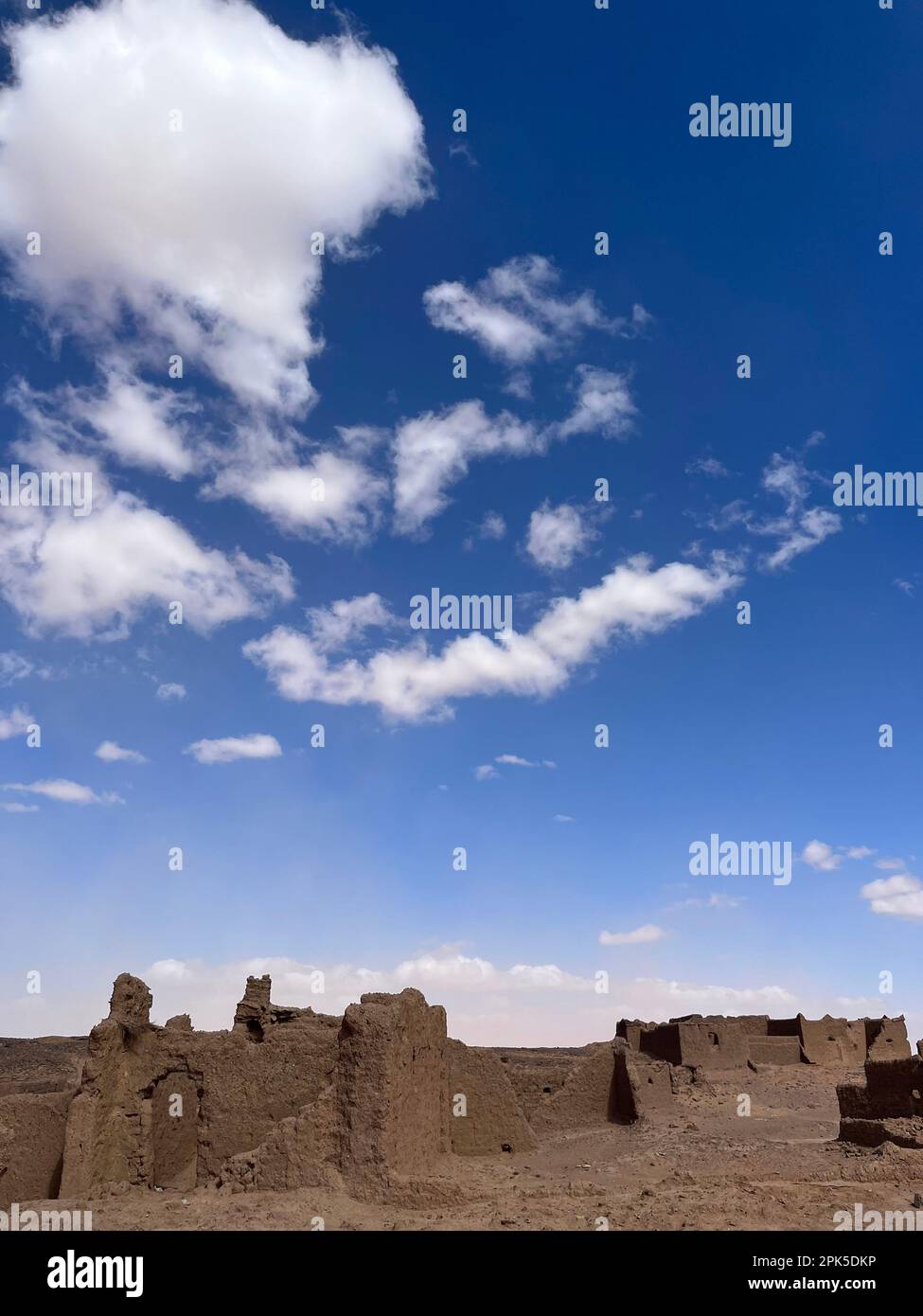 Merzouga, Morocco, Africa: panoramic road in the Sahara desert, ruined houses in an abandoned nomadic village near the fossil mines of Black Mountain Stock Photo