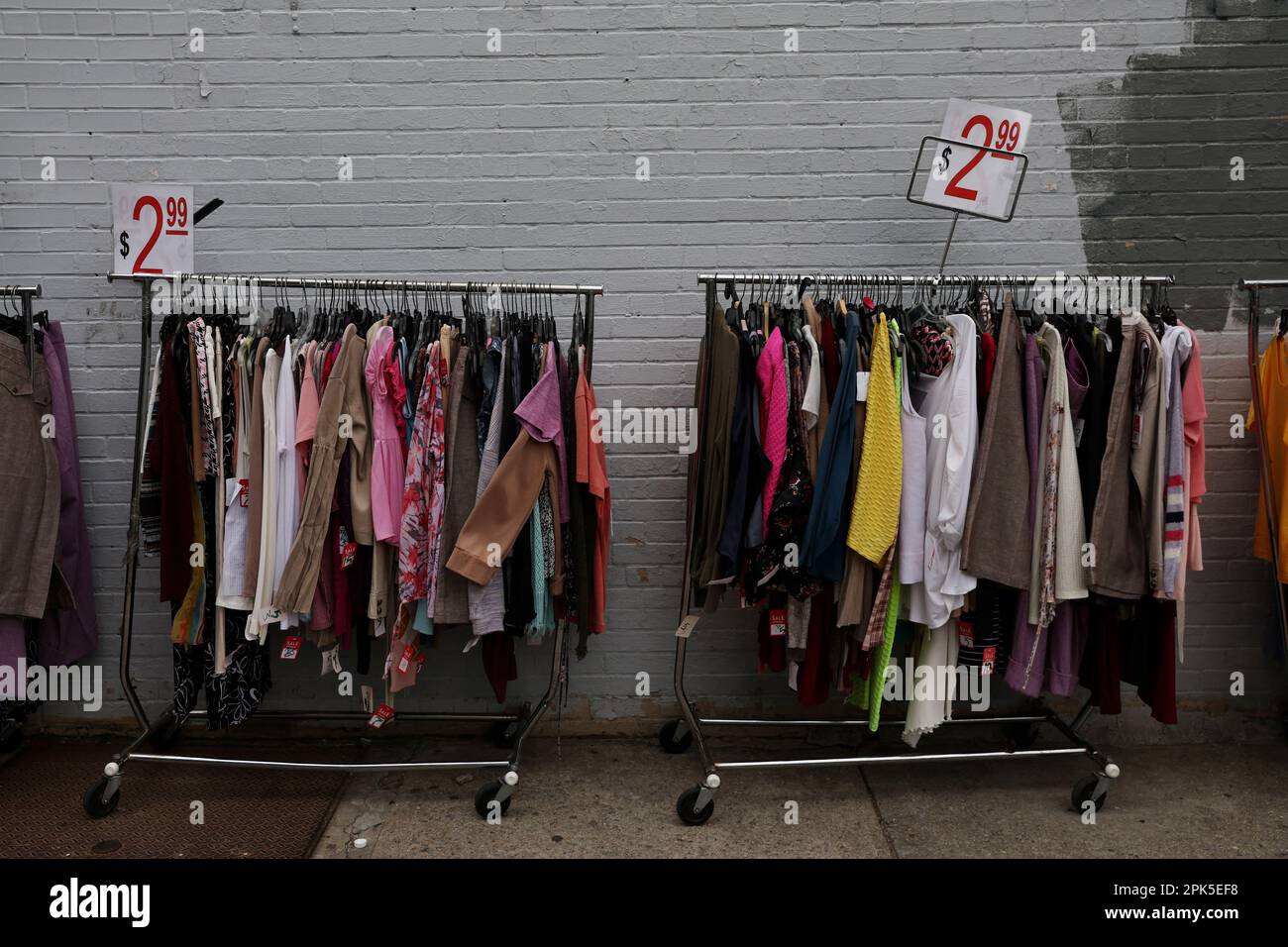 Discount clothes hang on a rack outside a store in the Brighton Beach