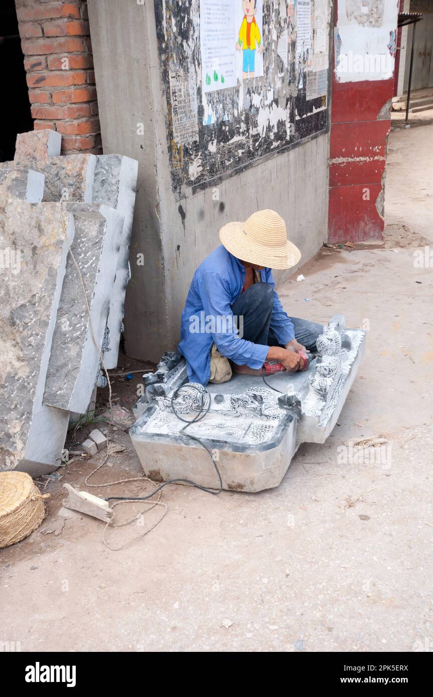 Chinese stone masons working on carving their intricate designs at a workshop in Jianshui Yunnan Province, China Stock Photo