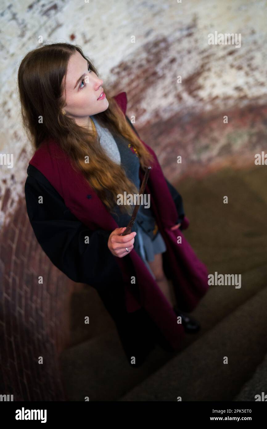 Harry Potter Witch Walking Up Spiral Stairway in Fortress Holding Wand at Ready | Robes Stock Photo