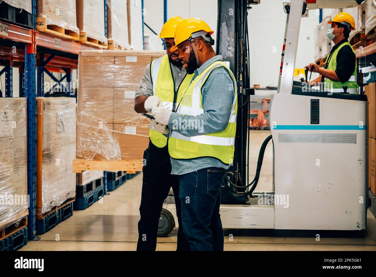 Professional warehouse worker moving cardboard boxes by forklift ...