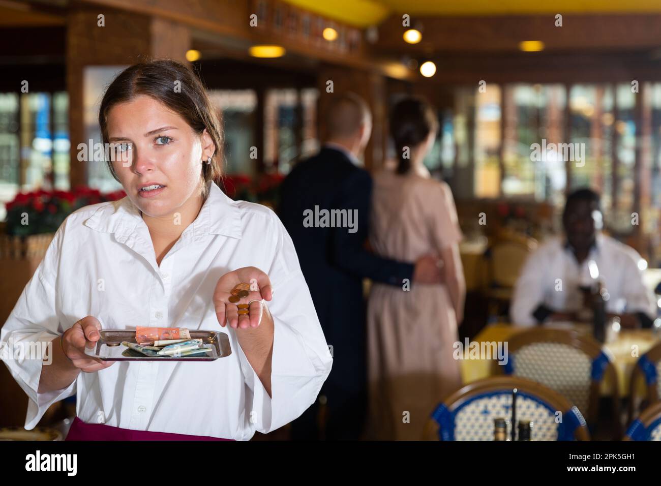 Woman waiter demonstrating her upset with small tip Stock Photo