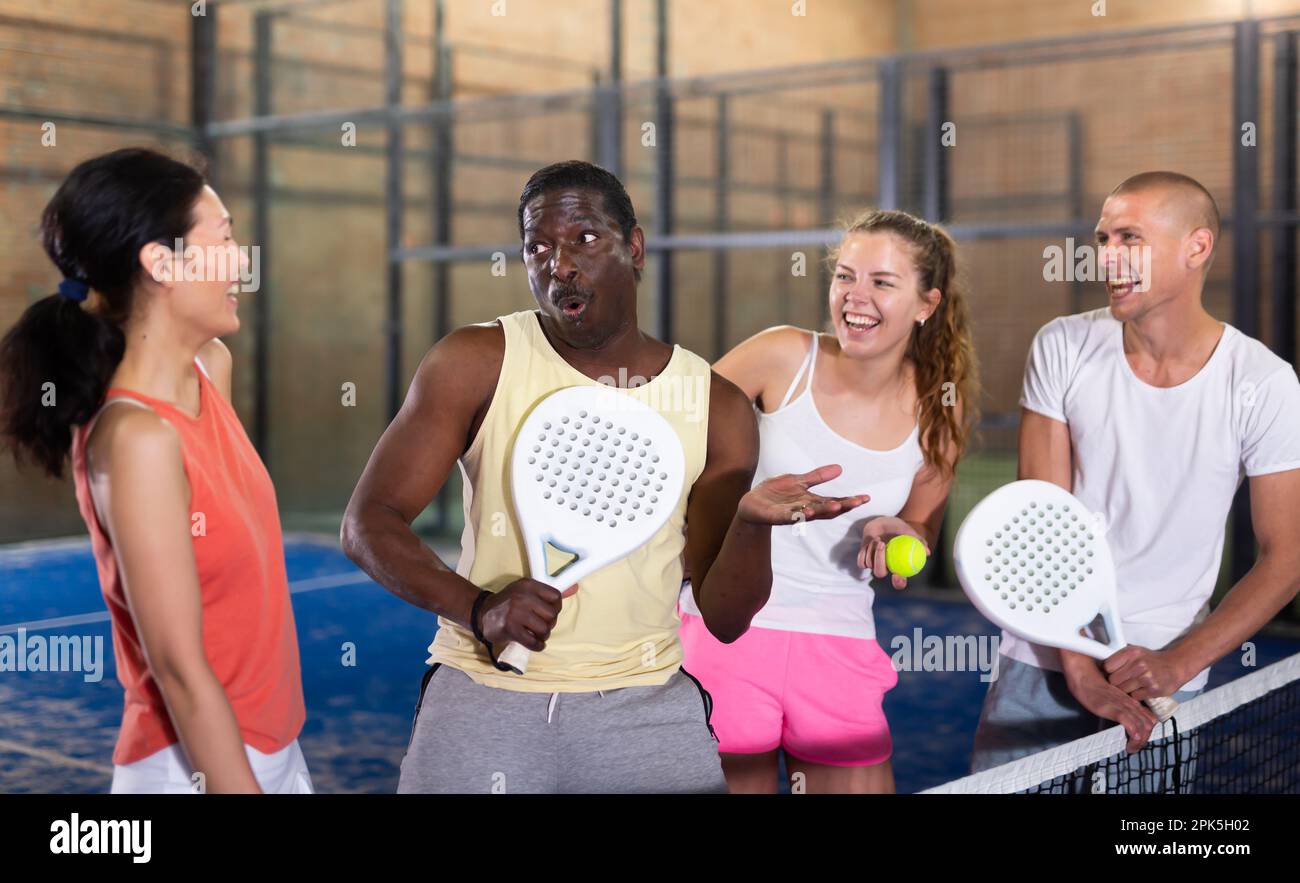 Two happy couples after playing padel on tennis court Stock Photo - Alamy