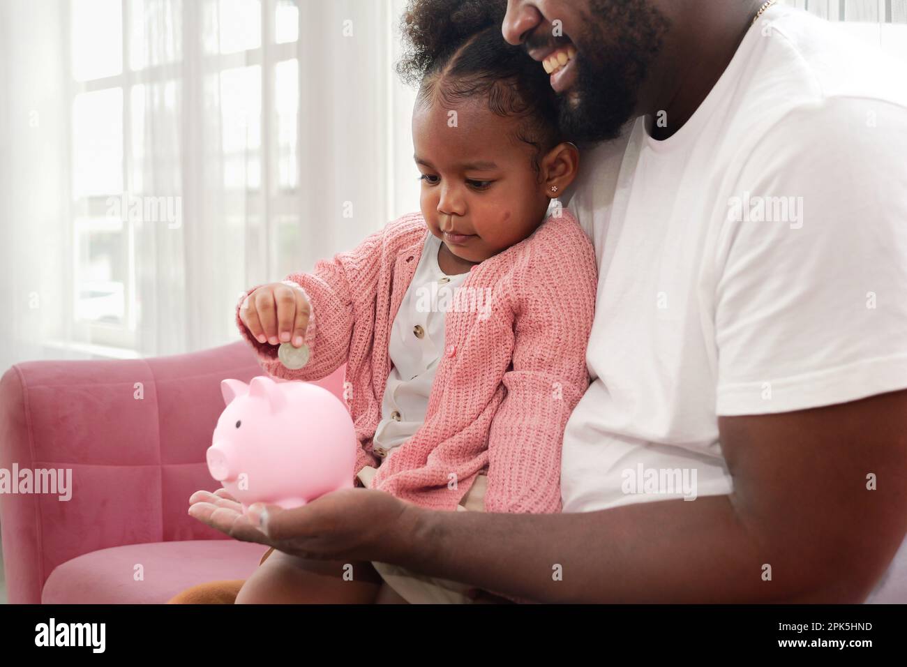 Little girl putting coin of cash into ceramic piggy bank Stock Photo ...