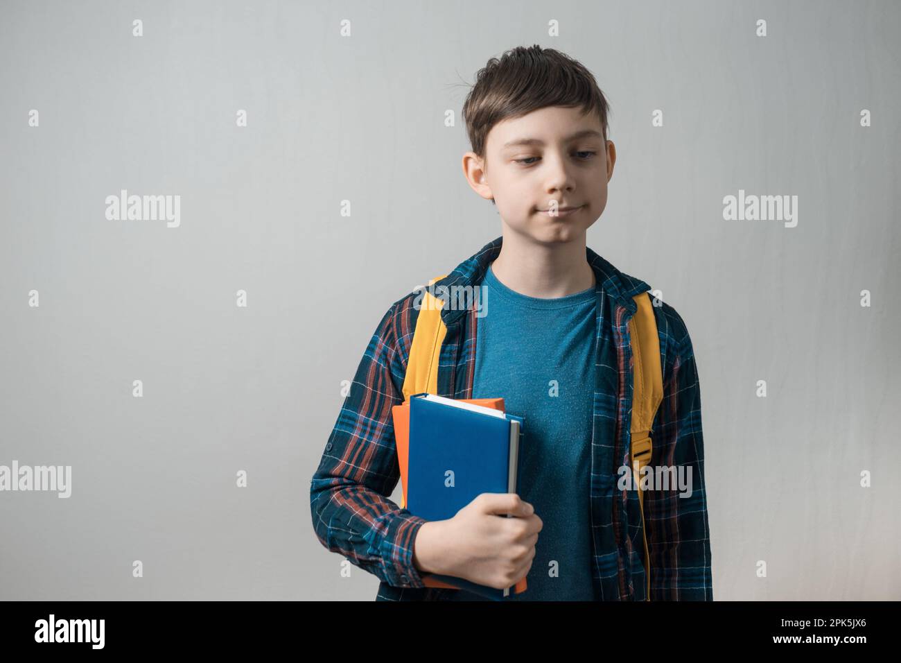 school boy holding stack of books on grey background Stock Photo - Alamy
