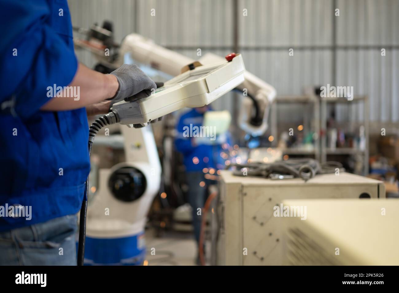 Engineer technician controlling robotic arms on computer laptop Stock Photo