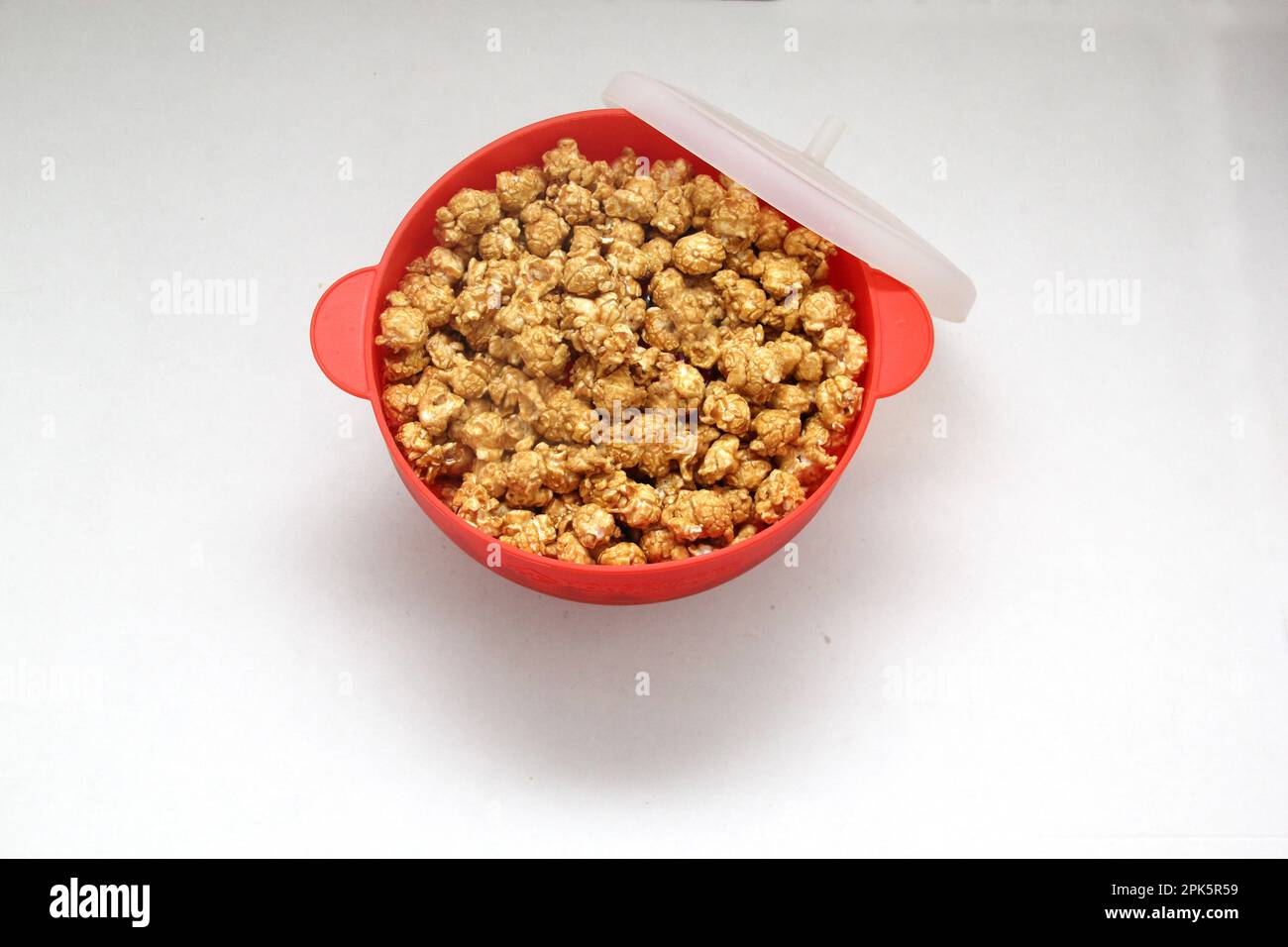 Collapsible red silicone container for microwave popcorn Stock Photo
