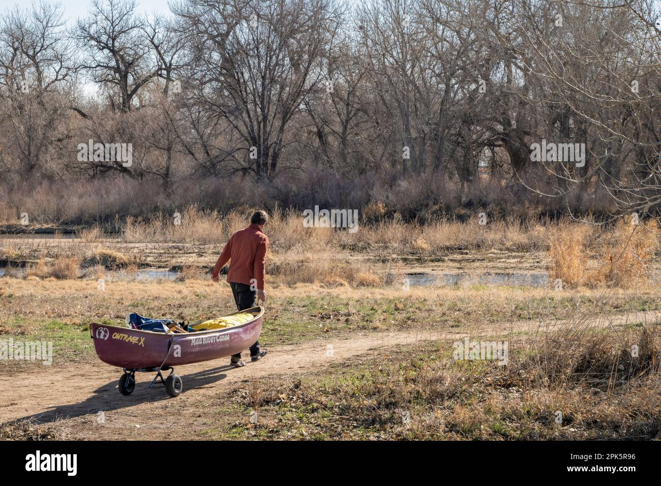 Evans, CO, USA - April 1, 2023: Female canoeist is towing a whitewater ...