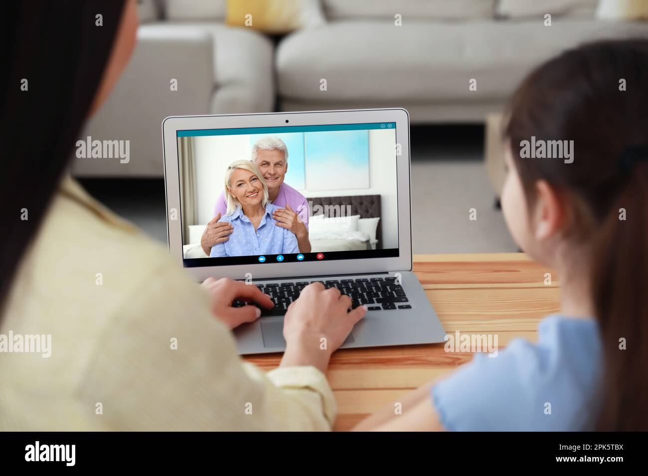 Mother and daughter having online meeting with family members via ...