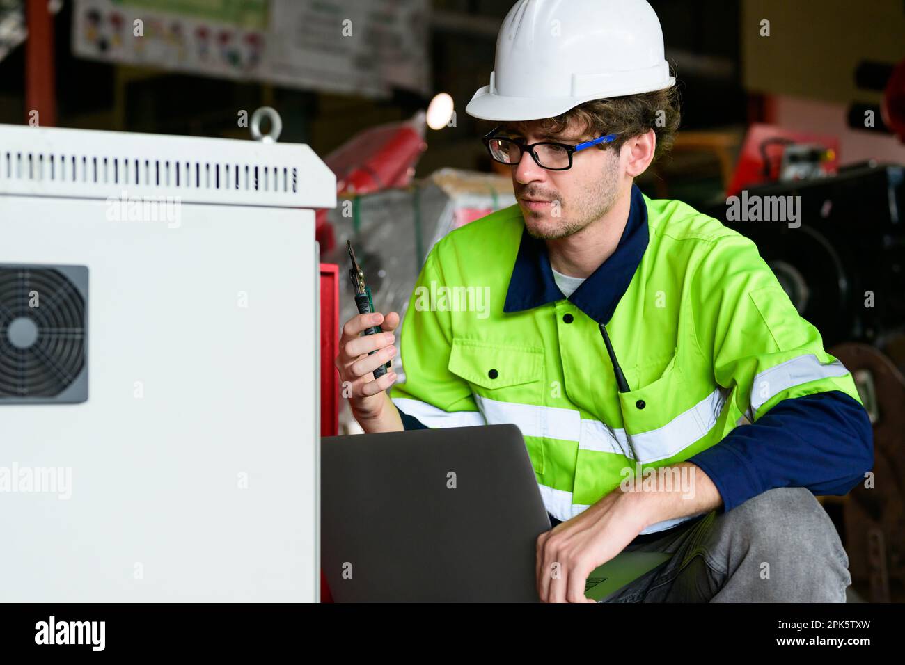 Technician engineer holding robot controller checking and repairing machine Stock Photo