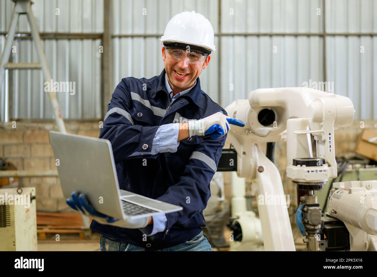 Engineer technician controlling robotic arms on computer laptop Stock Photo