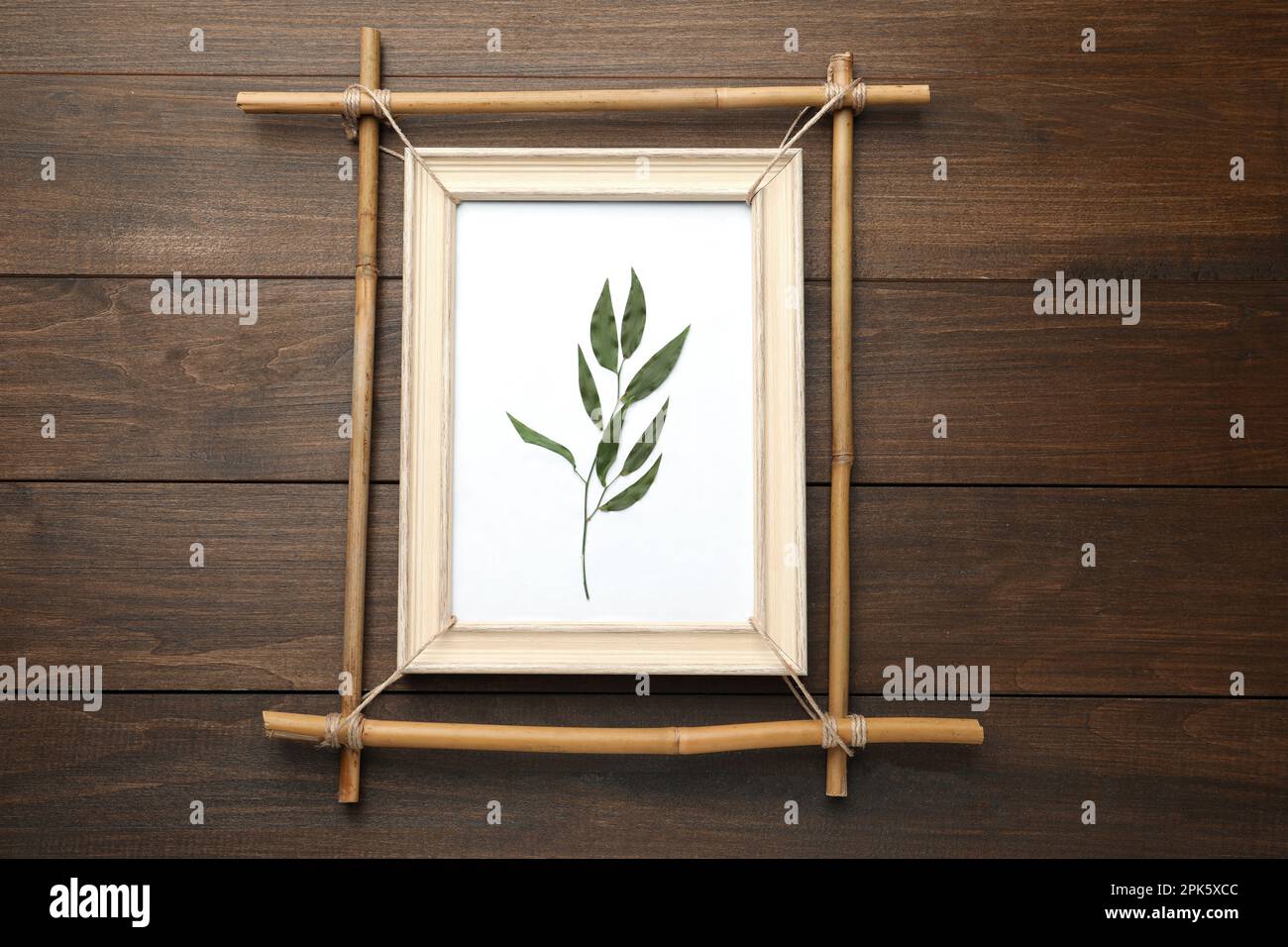 Bamboo frame with dried plant on wooden table, top view Stock Photo - Alamy