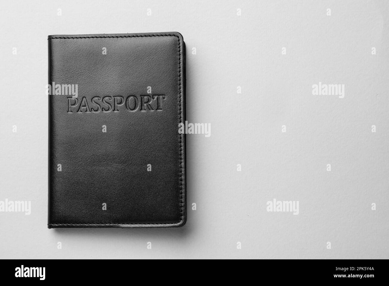 Passport in black leather case on light grey background, top view. Space for text Stock Photo