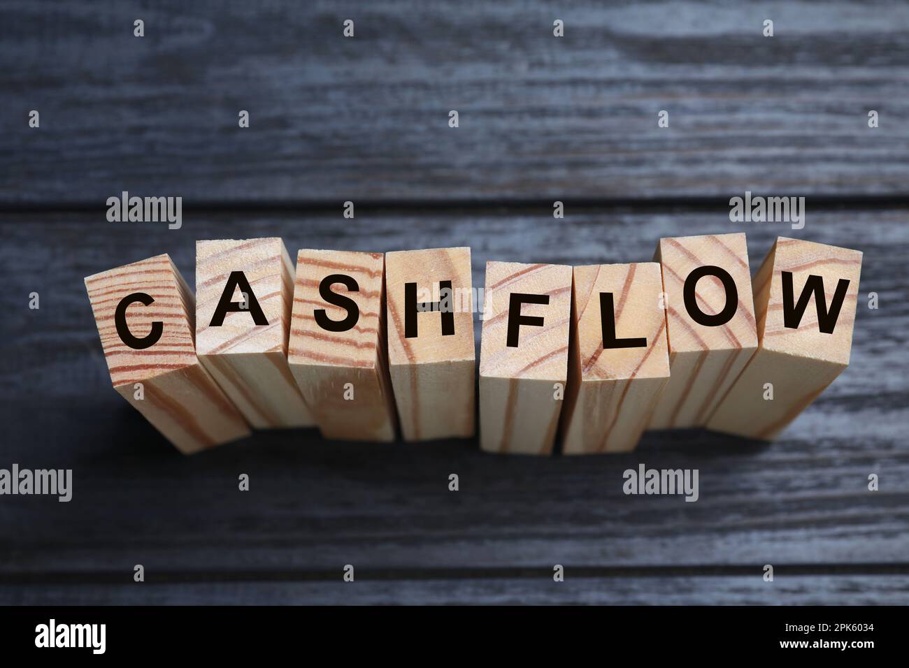 Blocks with phrase Cash FLow on black wooden background, above view