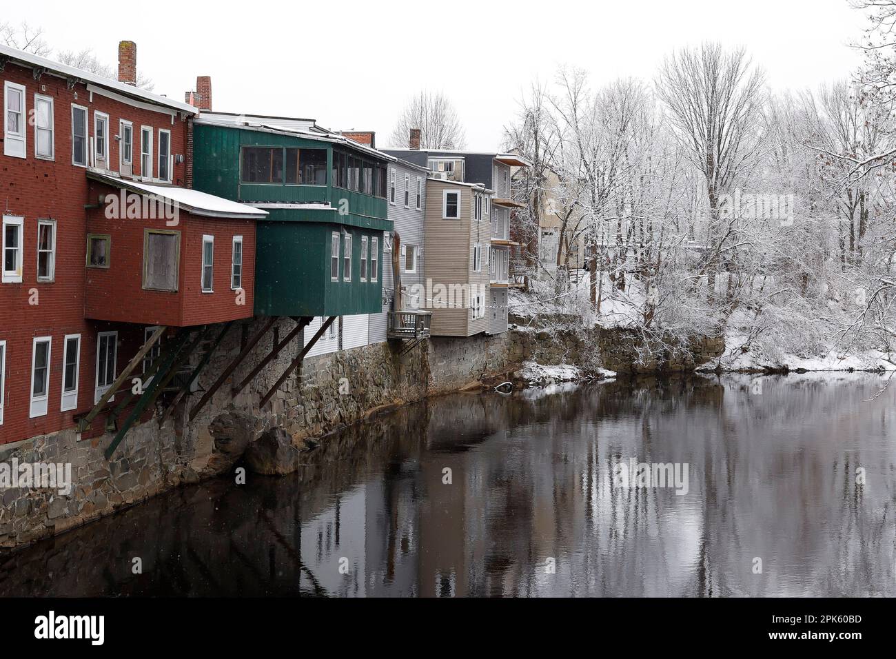 The backs of these apartments face the river in downtown Milford, NH.Taken from The Stone Bridge. This is The Souhegan River and reflections. Stock Photo