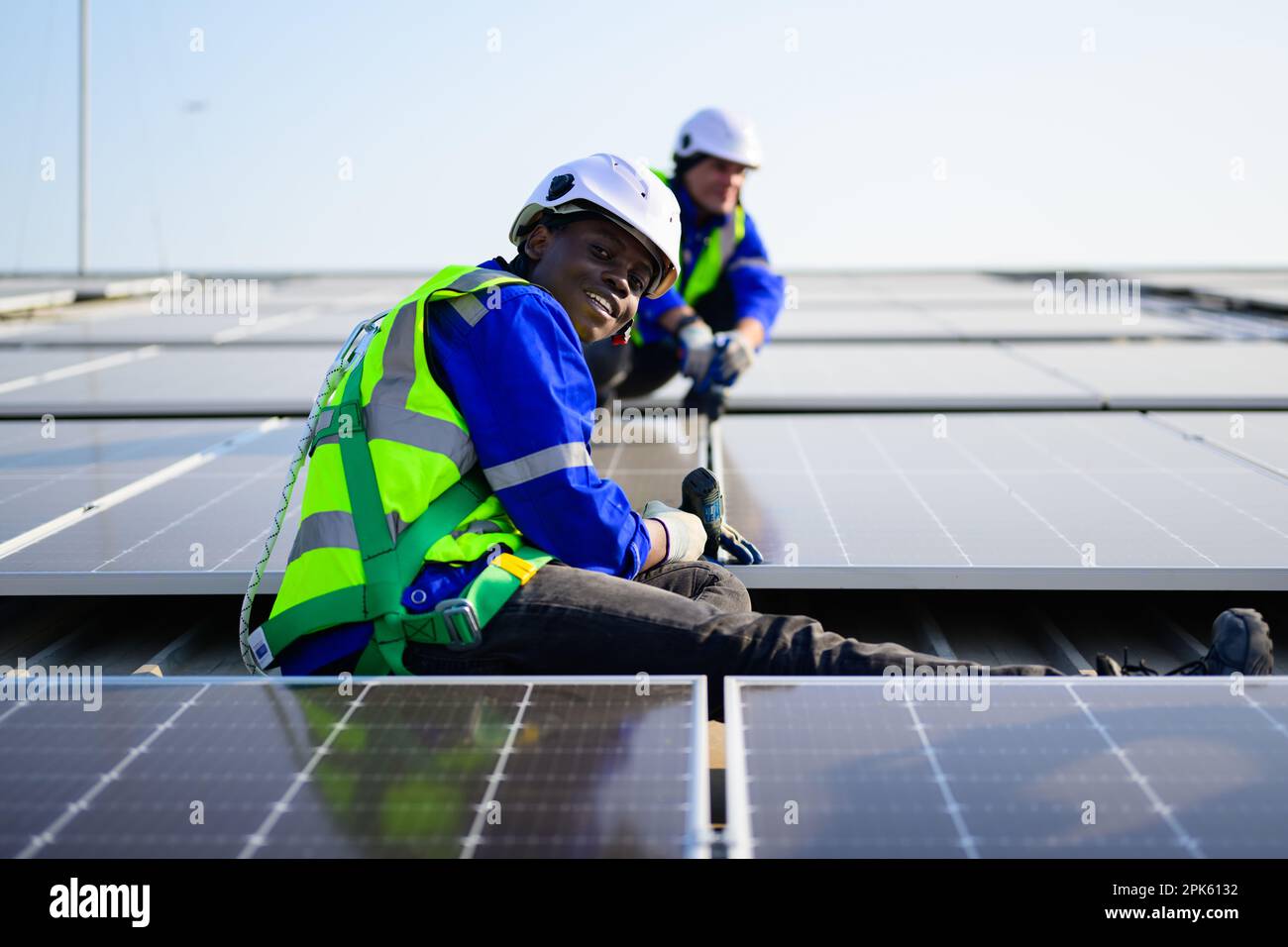 Professional technicians installing solar panels on rooftop of plant