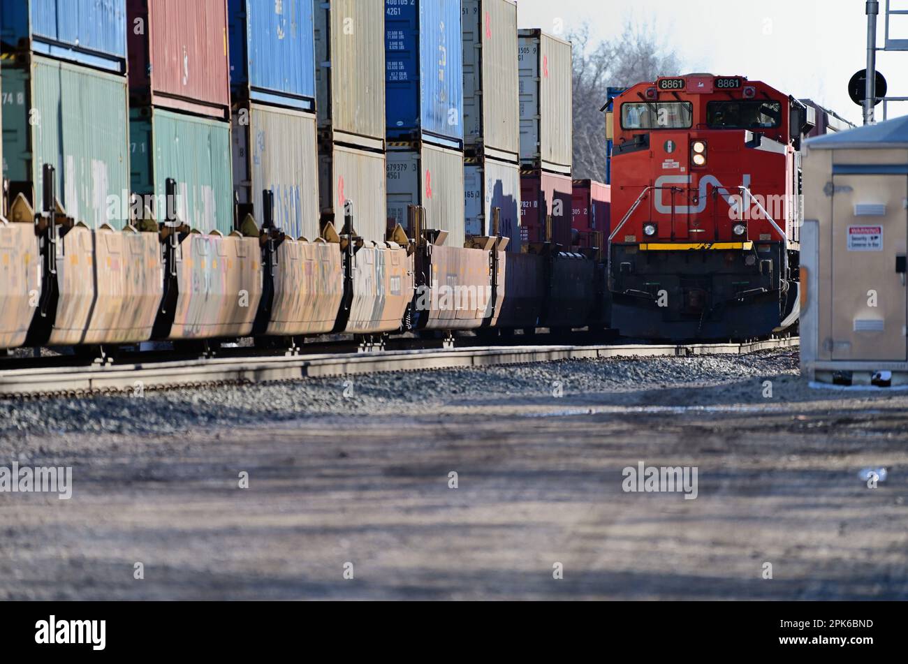 Dundee, Illinois, USA. A Canadian National Railway intermodal freight train passing another CN freight waiting on a siding in rural Illinois. Stock Photo