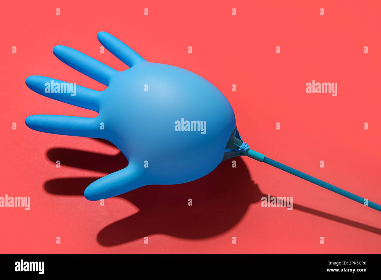 Inflated medical glove on red background Stock Photo