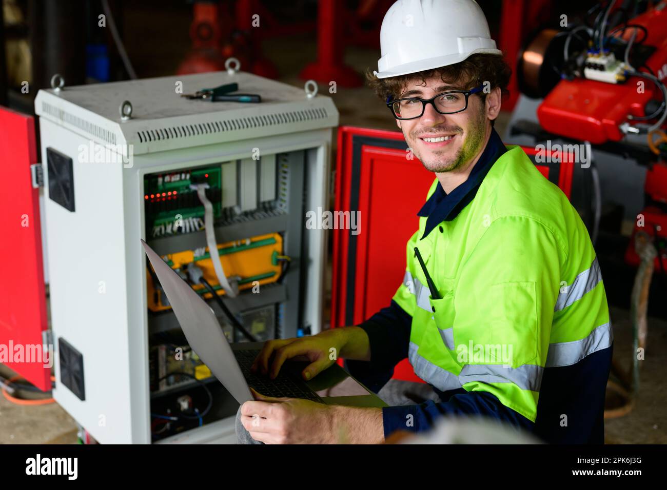 Technician engineer holding robot controller checking and repairing machine Stock Photo