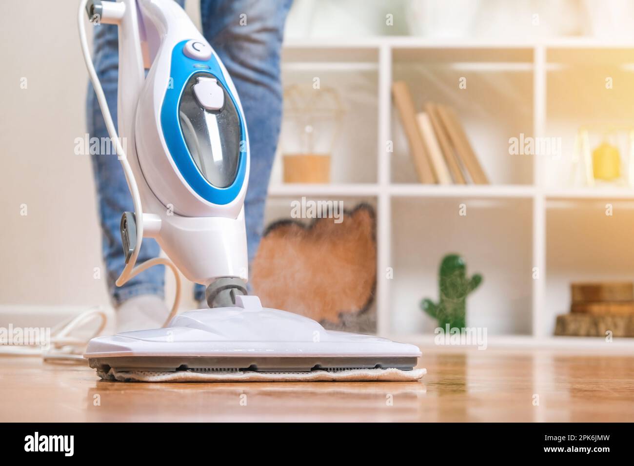 A man washes the floors with a steam mop. Floor treatment with hot ...
