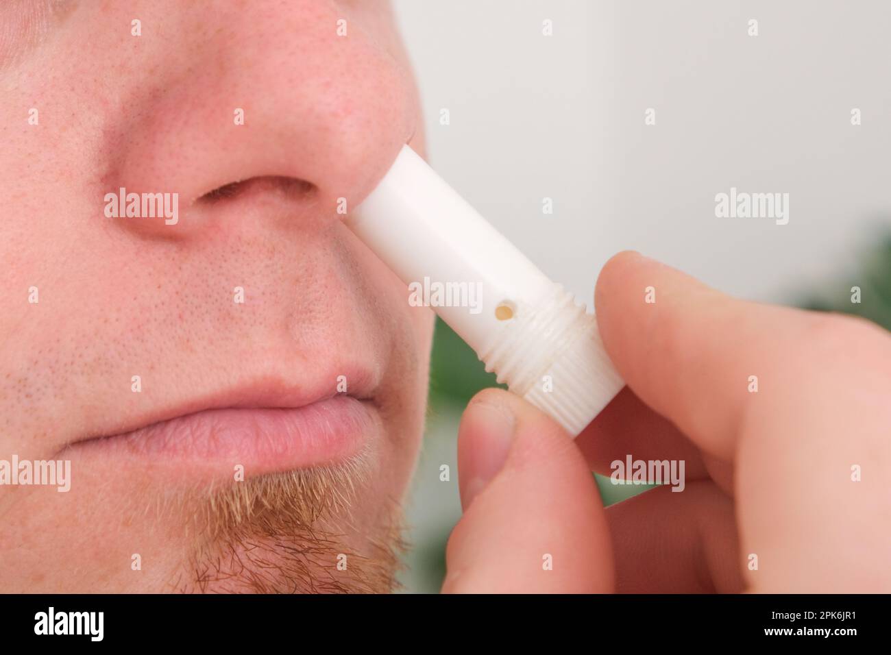 Adult man uses nasal stick inhaler to smell for relieve dizzy and faint