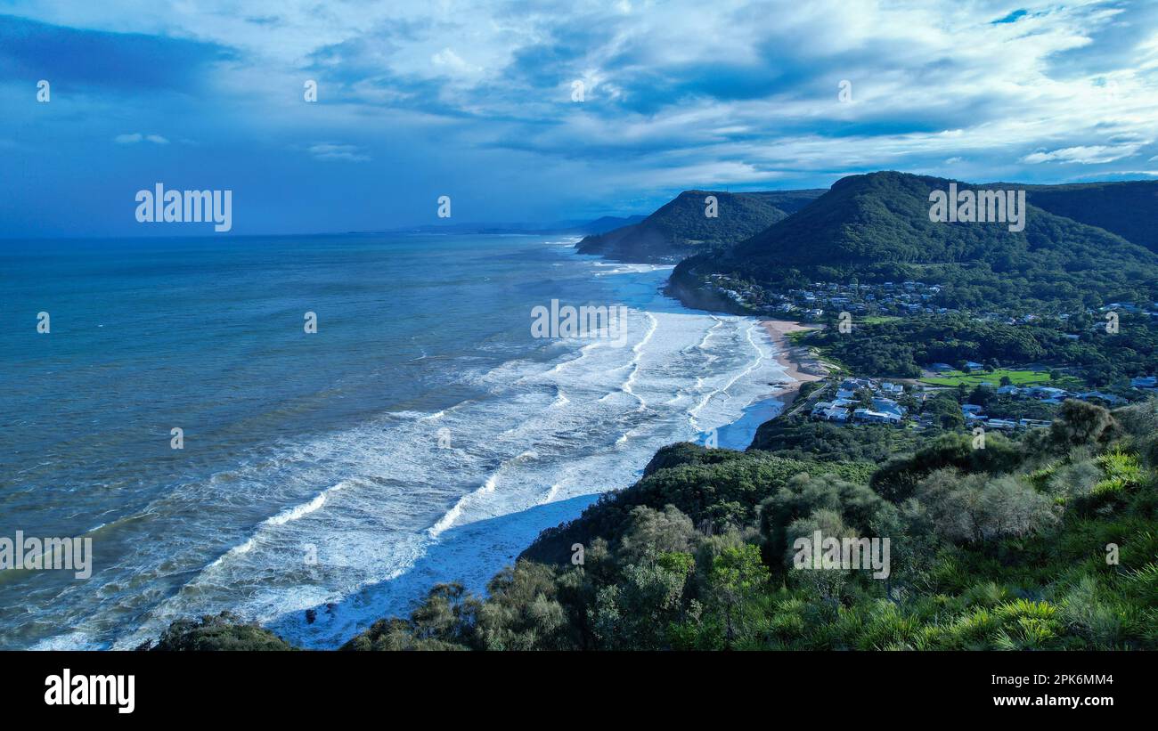 An aerial drone top view of the Seacliff bridge along the coastline on Pacific Ocean in Wollongong, New South Wales, Australia with ocean waves. Stock Photo