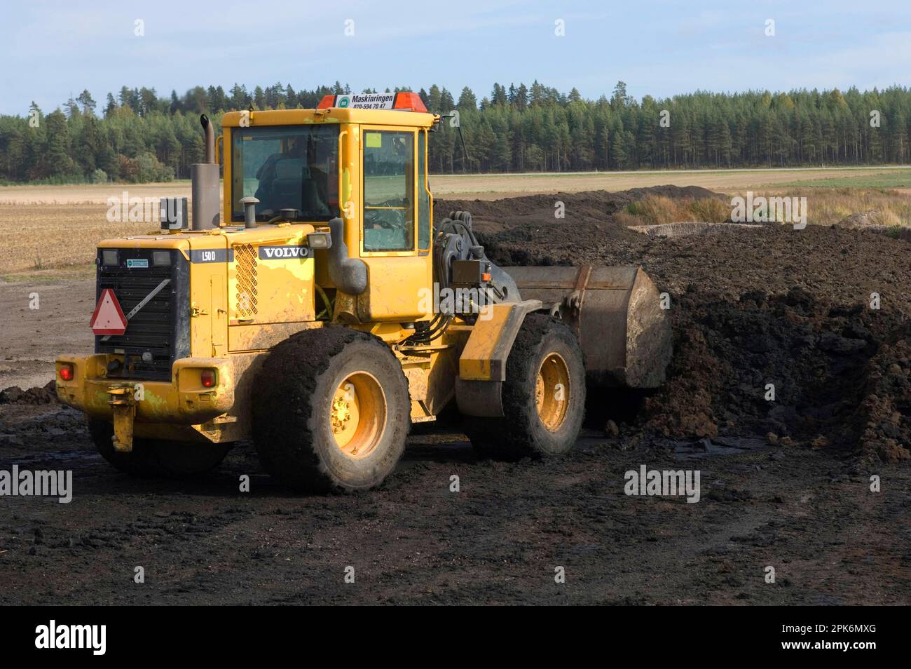 Volvo L50 D wheel loader, loading manure into the bucket to load the manure spreader, Sweden