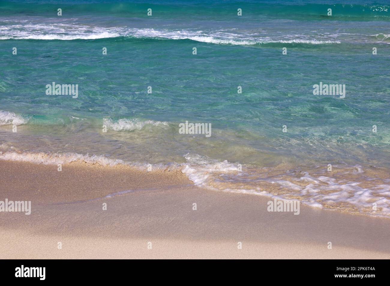 Tropical beach with sand on a ocean, view to blue waves. Caribbean coast, background for holidays Stock Photo